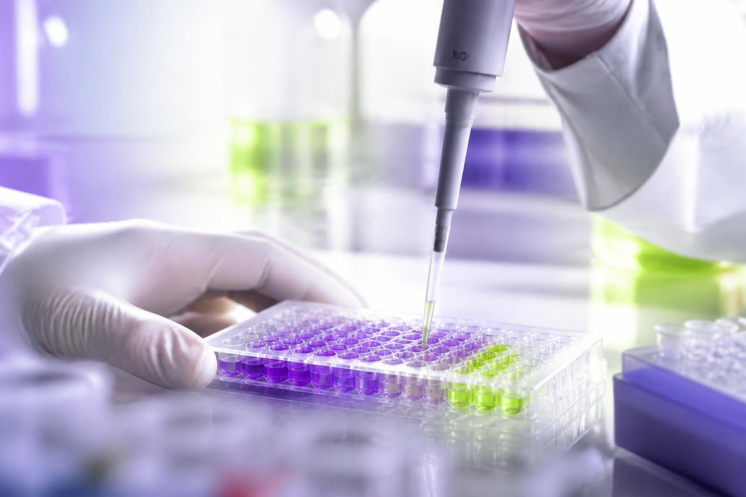 Researcher pipetting samples in an Atina Pharma laboratory